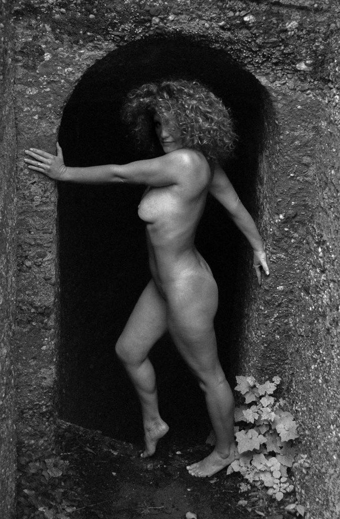 Femme nue de dos à l'entrée d'un souterrain