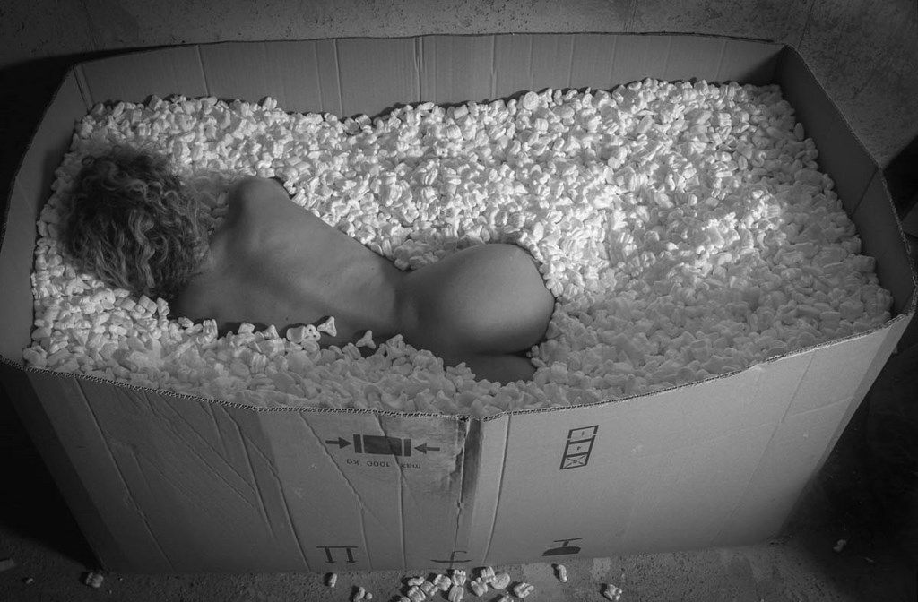 Femme nue dans un carton recouvert de chips