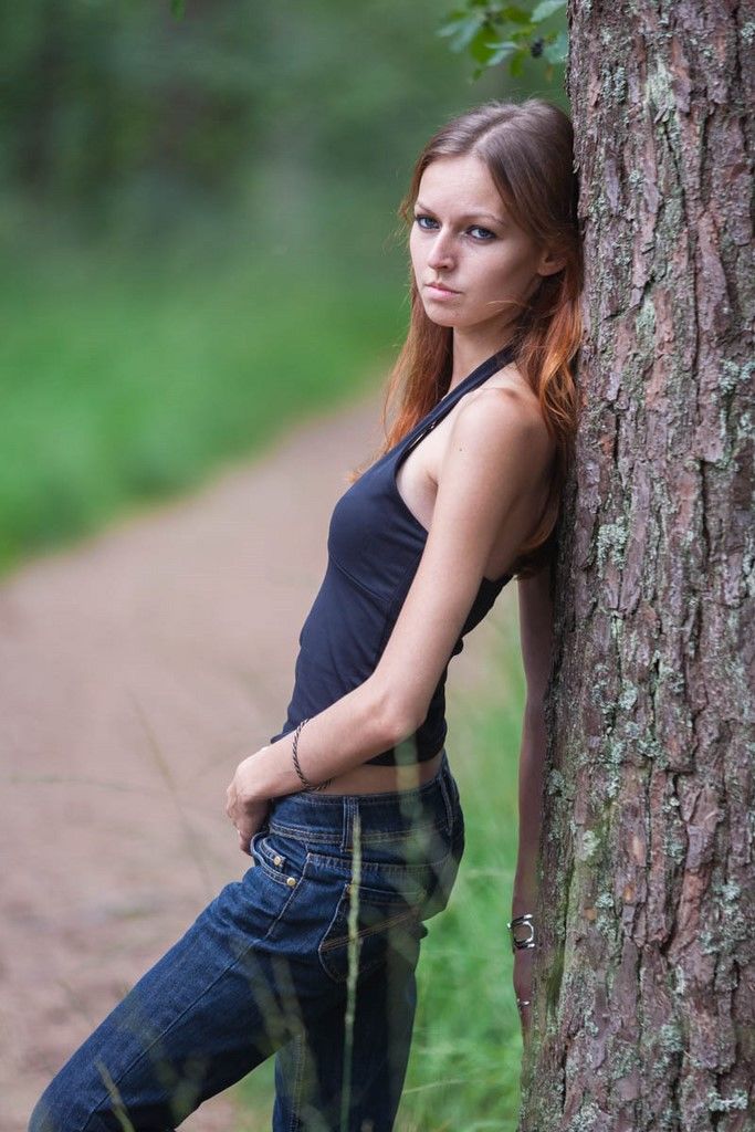 Portait de femme appuyée contre un arbre