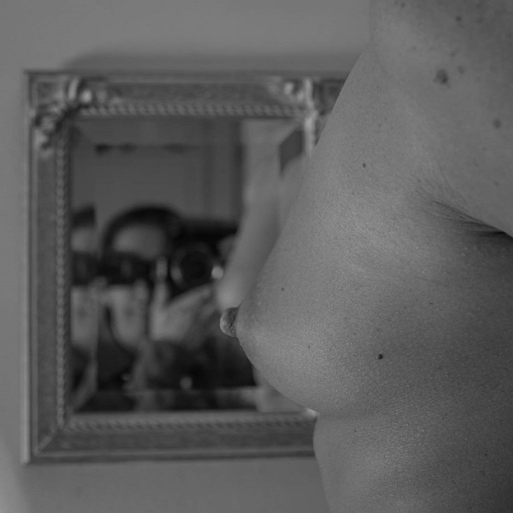 Autoportait du reflet de Christophe FETET dans un miroir devant un sein nu de jeune femm