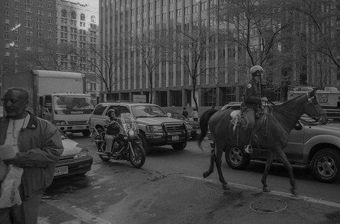 Un cheval de la police suivi d'un motard dans les rues de New-York