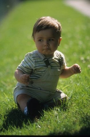 Portait de petit garçon assis dans l'herbe