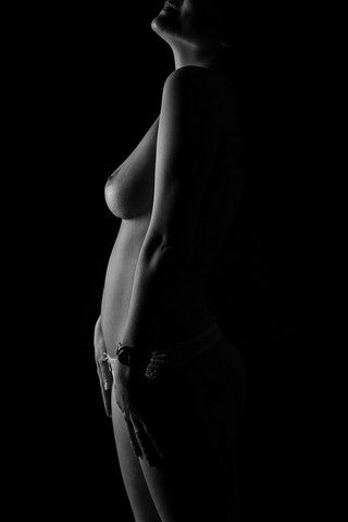 femme seins nus en calir obscur