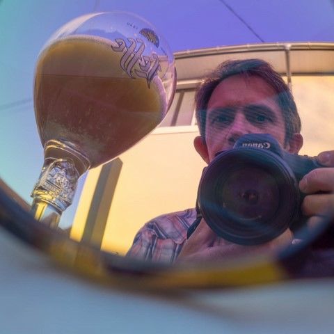 AAutoportait de Christophe FETET jouant avec le reflet de lunette de soleil avec une verre de bière